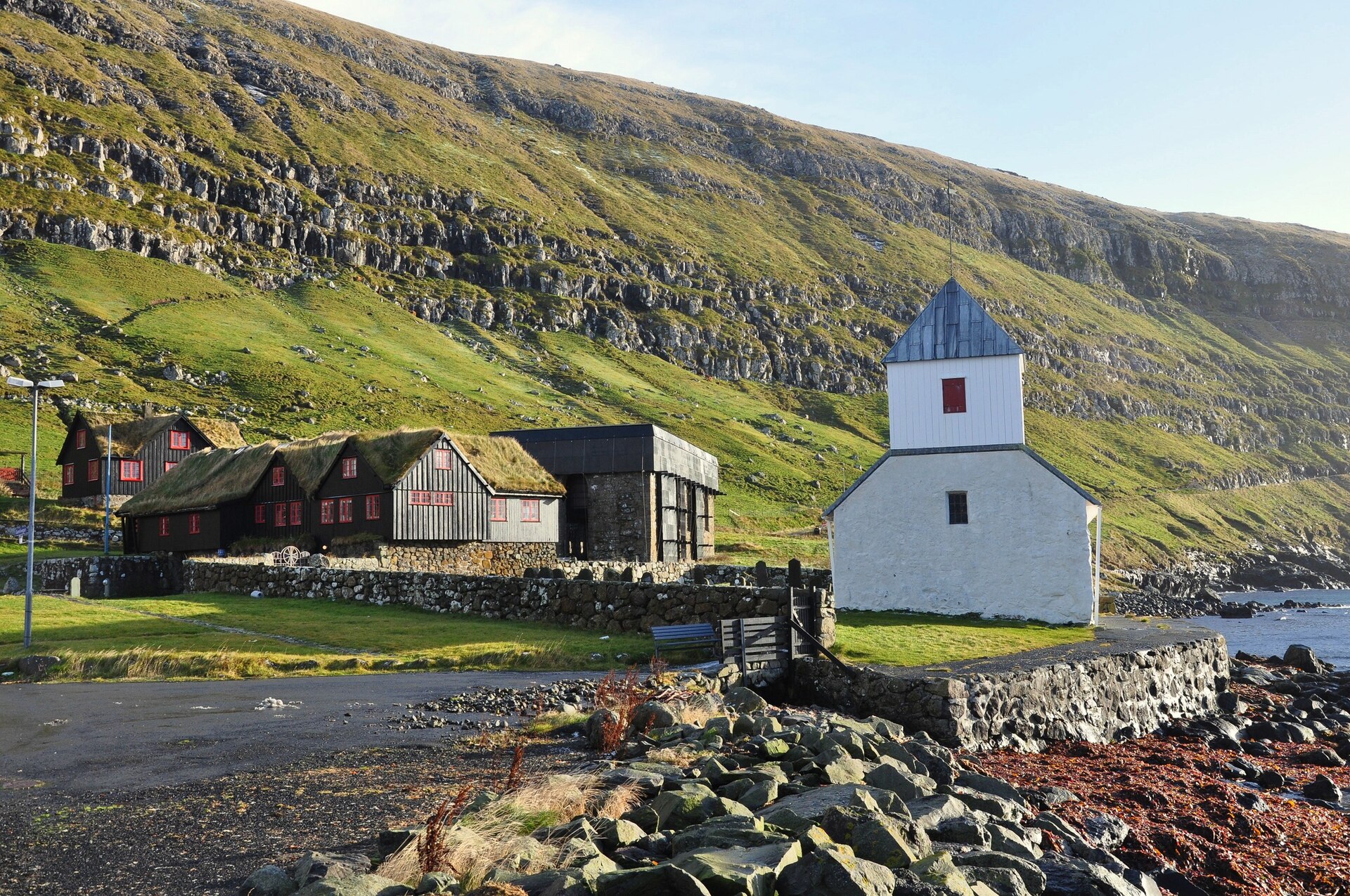 Kirkjubøur village with its historic church, turf-roofed buildings and the sea